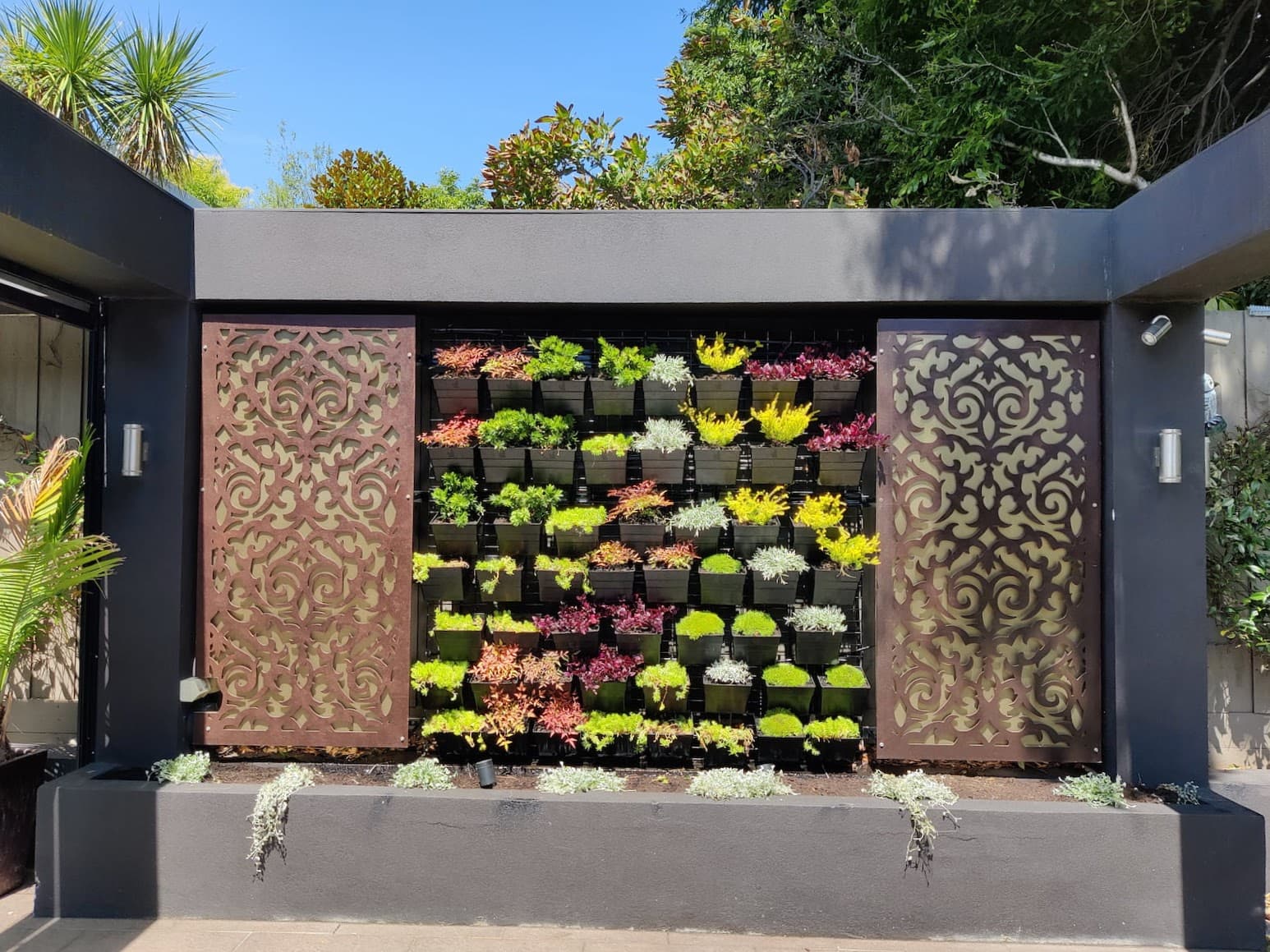 Vertical garden feature wall with colourful planting and lighting
